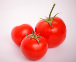 Three vibrant red tomatoes on a clean white background.