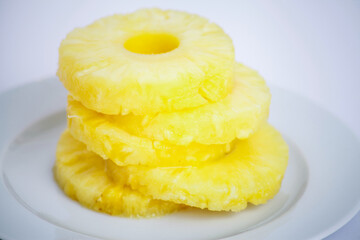 Stack of Fresh Pineapple Slices on a White Plate
