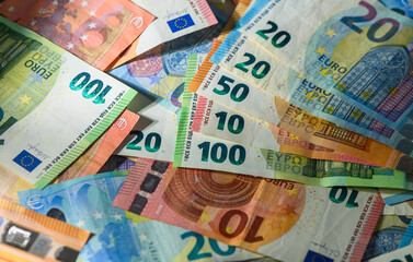 Euro banknotes spread flat on wooden table closeup