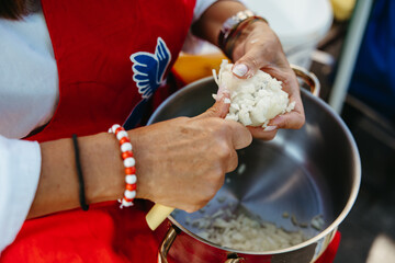 Fototapeta premium Close-up of mature woman chopping onion for traditional outdoor meal