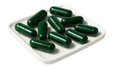 Green capsule pills on a white tray.