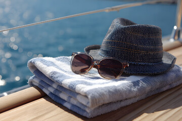 a hat  sunglasses and towel on a boat