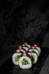 classic roll with cucumber rice cucumber nori on a black stone background