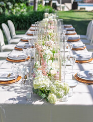 Elegant Outdoor Wedding Table Setting For an Event With Floral Centerpieces and Glassware