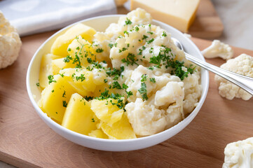 Cauliflower with a delicious gouda cheese sauce and boiled potatoes on a plate. Budget friendlich and easy to cook meal