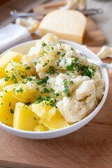 Cauliflower with a delicious gouda cheese sauce and boiled potatoes on a plate. Budget friendlich and easy to cook meal