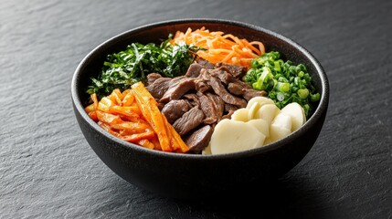 Delicious bibimbap served in a black bowl with fresh vegetables and beef.