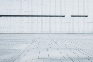 Fototapeta premium Empty clean stone tile floor with a minimalist modern white building wall background.