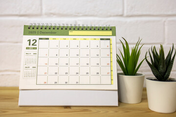 Hello, December 2025. A desktop calendar for planning on the table.