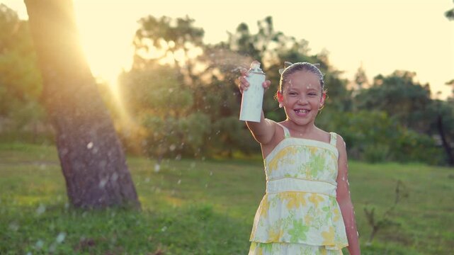 Niña con espuma de aerosol divertida feliz jugando en bosque al aire libre en un parque en el atardecer disfrutando de su infancia ni&ntilde;a feliz y contenta sonriente 