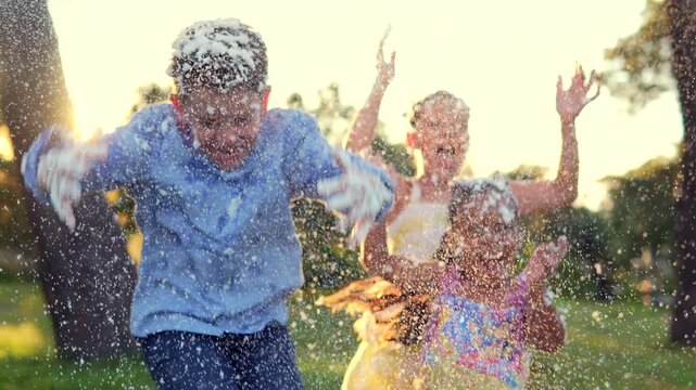 Tres ni&ntilde;os felices amigos hermanos disfrutando divertidos jugando con espuma al aire libre en un parque en el atardecer entretenimiento infantil ni&ntilde;os sonriendo alegres y contentos