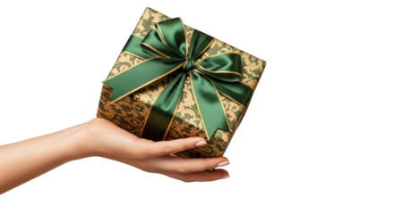 Woman's hand elegantly presents a gift wrapped in ornate paper and a lush green ribbon, isolated.