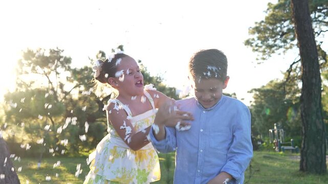 dos ni&ntilde;os felices amigos hermanos divertidos disfrutando y jugando con espuma en el parque en un hermoso atardecer viviendo su infancia con inocencia sonrientes y alegres en el verano