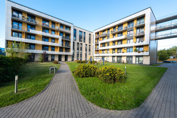 Modern Apartment Complexes With Green Courtyard and Paved Pathways