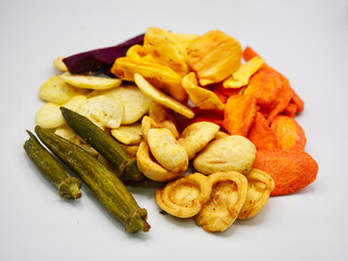 A pile of assorted dried fruit and vegetable chips, showing natural colors and crispy textures. Great for organic food, diet menu, and snack concepts