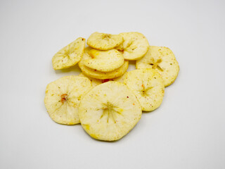 Thin slices of dried apple chips arranged neatly on a clean white surface. Great for illustrating healthy food, fruit snacks, natural diet, and organic lifestyle