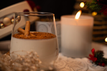 Rompope with cinnamon sticks celebrating christmas with a lit candle