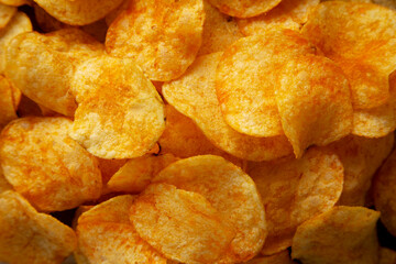 Homemade Flavored Cheese Potato Chips on a Wooden Board, top view.