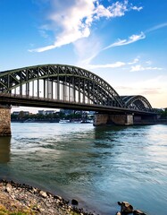 Fototapeta premium Steel arch bridge over a river, dramatic sky