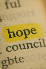 Close-up macro shot of printed word hope highlighted in yellow marker, showing detail on paper texture. Perfect for concept visuals of optimism, positivity, and motivation.  
