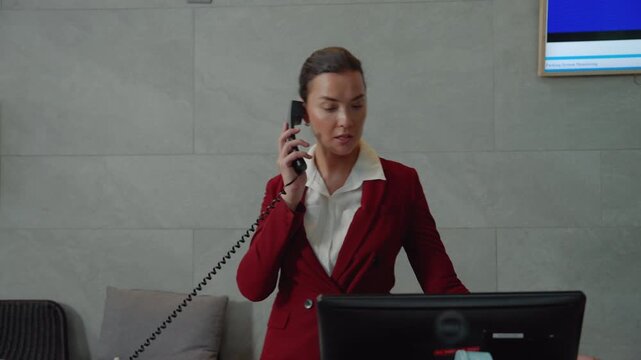 The hotel receptionist is talking on the phone with a customer to contact the hotel reservation