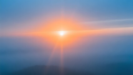 Fototapeta premium The sun rises above misty mountains creating beams of light