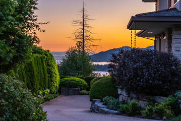 Entrance of luxury house with nice green Summer landscape at night in Vancouver, Canada, North America. August 2025
