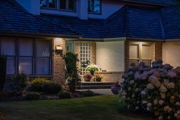 Entrance of luxury house with nice green Summer landscape at night in Vancouver, Canada, North America. August 2025