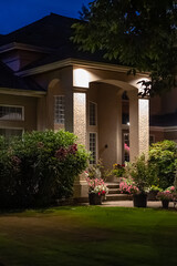 Entrance of luxury house with nice green Summer landscape at night in Vancouver, Canada, North America. August 2025