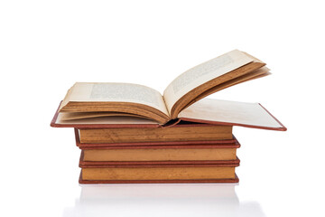 Open old vintage book on a stack for education, knowledge, and library learning concepts, isolated on white background with clipping path.