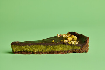 Savor the Delicious Matcha Chocolate Tart Slice against a Vibrant Green Background
