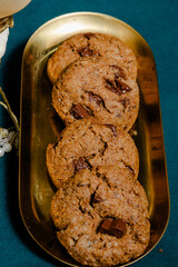 Chocolate chunk cookies on a gold tray offer a simple yet appealing visual.