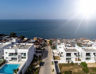 Coastal Haven: An aerial perspective showcases a modern residential area featuring sleek, contemporary homes with inviting pools, set against the stunning backdrop of a vast.