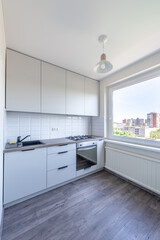 Kitchen interior with window, wooden table and lamp.