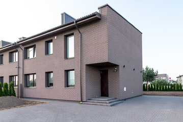 Modern Brick Row House Exterior with Clear Sky and Minimalist Landscape