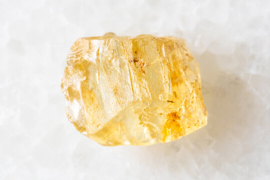 sample of raw yellow scapolite crystal on white