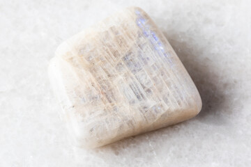 polished belomorite moonstone rock on white marble