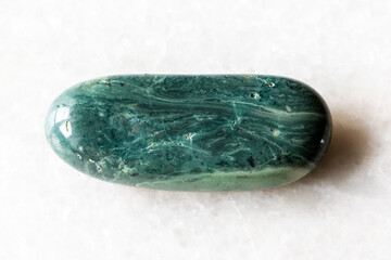 tumbled trass chernomorite mineral on white marble