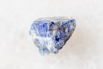 sample of raw benitoite stone on white marble