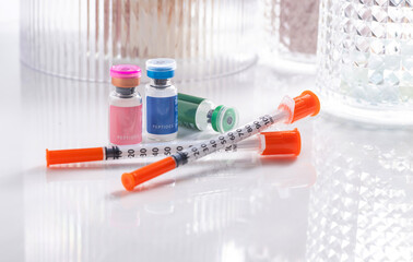 Close up of Vials with Various Injectable Peptides Next to Syringes