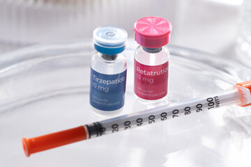 Close up of Vials with Retatrutide and Tirzepatide Research Peptides Next to Syringe