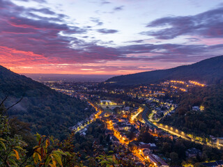 Sonnenaufgang an der Wolfsburg über Neustadt im Herbst mit Nebel und Lichtern in der Stadt