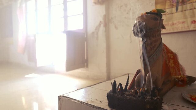 Adorned Cow Statue in Temple with Incense Smoke and Sunlight