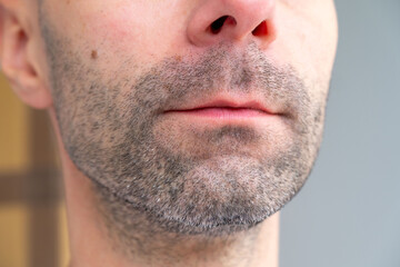 Obraz premium Close-up side profile man’s face with short stubble and early gray hairs, Facial hair detail, Natural beauty in aging, Signs maturity, highlighting facial texture and natural aging, neutral background