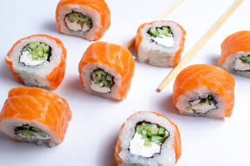 Pieces of delicious japanese sushi frozen in the air. Sushi roll isolated on white background. California sushi roll with tuna, vegetables and unagi sauce closeup