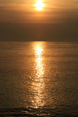 Shimmering Golden Ocean Waves Reflecting Sunlight At Sunset