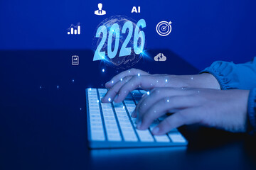 Artificial intelligence and business technology in 2026 concept with illuminated numbers, human hands typing, cloud computing, analytics, and futuristic digital blue background.