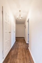 Bright Home Hallway Interior with Wooden Floor and Decorative Light Fixture