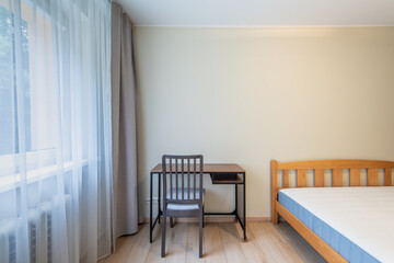 Minimalistic Bedroom With Wooden Bed and Desk Arrangement Near a Window