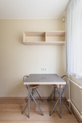Compact Dining Setup with Minimalist Chairs and Functional Shelving